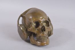A BRONZE SKULL with headphones. 6ins high.