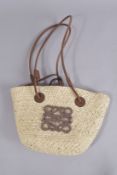 A HESSIAN BAG with brown leather handle. 12ins high.