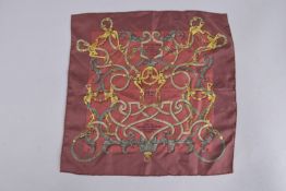 A HERMES SQUARE WINE COLOURED SILK SCARF with scrolls. 16ins x 16ins, in a Hermes bag. 319.