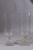 A PAIR OF GLASS HURRICANE LAMPS on square bases. 13ins high.