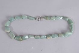 A GREEN JADE NECKLACE set with twenty-two stones. 29ins long.