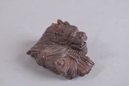 A JAPANESE CARVED DRAGON NETSUKE, signed. 2.25ins.