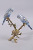A BLUE BUDGIE AND METAL CANDLESTICK. 10ins high.