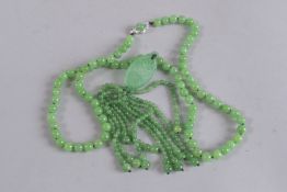 A GOOD STRING OF JADE BEADS with tassel and white gold clasp.