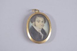 A 14CT GOLD OVAL PORTRAIT PENDANT, portrait of a man, the reverse with hair.