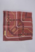 A CARTIER BROWN BELT AND CHINESE PATTERN SILK SCARF, 32ins x 32ins. Unused in a Cartier box.