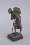A BRONZE ARAB with walking stick. 9ins high.