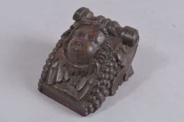 AN EARLY CARVED WOOD ANGEL HEAD BRACKET. 5ins x 3.5ins.