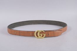 A GUCCI TAN LEATHER BELT. 44ins long.