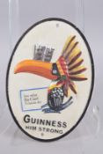 A PAINTED CAST IRON OVAL GUINNESS SIGN. 11ins x 8ins.