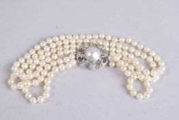 A TRIPLE ROW PEARL CHOKER with pearl and diamond clasp.