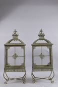 A PAIR OF METAL RECTANGULAR LANTERNS on four curving feet. 29ins high.