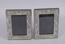 A PAIR OF SILVER AND ENAMEL PHOTOGRAPH FRAMES. 7.5ins x 5.5ins.