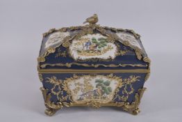 A GOOD CONTINENTAL PORCELAIN CASKET AND COVER, painted with birds and flowers, with gilt metal