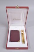 A CARTIER BOXED WALLET, PEN AND PENCIL. 8ins x 6ins.