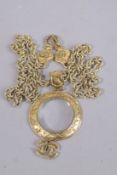 A VINTAGE CHANNEL MAGNIFYING GLASS on a long gilt chain.