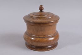 A GOOD LARGE LEAD LINED WOODEN CIRCULAR TOBACCO JAR AND COVER with acorn finial. 7ins diameter.