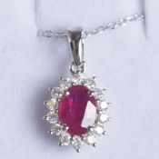 AN 18CT WHITE GOLD OVAL RUBY AND RBC DIAMOND CLUSTER PENDANT on an 18ct white gold chain, boxed.