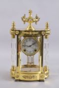 A GOOD GILT METAL REGULATOR CLOCK with column sides, with urn finial. 16ins high.