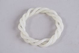 AN ARTICULATED WHITE JADE BANGLE. 3.25ins diameter.