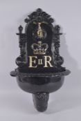 A BLACK PAINTED CAST IRON POST, E.R. 26ins high.