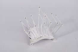A CHRISTOPHER DRESSER SIX-DIVISION SILVER PLATE TOAST RACK.