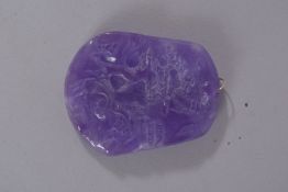 A CARVED LILAC JADE PENDANT.