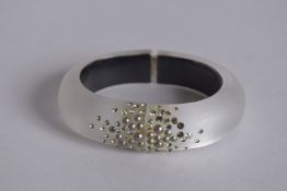 AN ALEXIS BRITTAR HAND CARVED BRACELET.