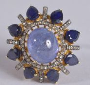 A LARGE AND EXCITING DRESS RING SET WITH AND OVAL CABOCHON TANZANITE, PEAR SHAPE SAPPHIRES AND