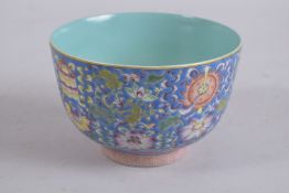 A CHINESE BLUE GROUND FAMILLE ROSE PORCELAIN BOWL, with turquoise glaze interior. 13.5cm diameter.