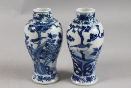A PAIR OF CHINESE BLUE AND WHITE PORCELAIN VASES, painted with birds, trees, and flora, 18cm high.
