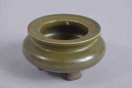 A CHINESE TEA DUST GLAZE TRIPOD CENSER, with character mark to base, 10cm diameter.