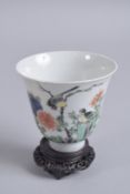 A FINE CHINESE FAMILLE VERTE PORCELAIN CUP AND HARDWOOD STAND, painted with birds and flora, the