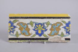A FINE 17TH CENTURY PERSIAN SAFAVID GLAZED POTTERY BORDER TILE, 24cm long.