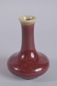 A CHINESE OX BLOOD GLAZE PORCELAIN BOTTLE VASE, 14cm high.