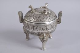 A FINELY ENGRAVED CHINESE WHITE METAL TWIN HANDLE TRIPOD CENSER AND COVER, 14cm high.