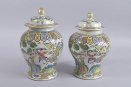 A NEAR PAIR OF 19TH CENTURY CHINESE POLYCHROME PORCELAIN JARS AND COVERS, (af), 29cm high and 27cm