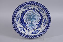 A TURKISH OTTOMAN GLAZED POTTERY CHARGER, depicting the tree of life, 35cm diameter.