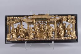 A FINE CHINESE GILDED RELIEF CARVED OPENWORK WOODEN PANEL, 23cm x 60cm overall.