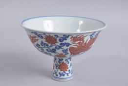 A CHINESE BLUE AND WHITE PORCELAIN STEM CUP, with red phoenix and lotus, 17.5cm diameter.