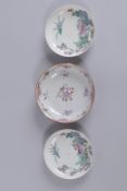 A PAIR OF 19TH CENTURY FAMILLE ROSE PORCELAIN SAUCERS, together with another single saucer, (3).