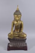 A FINE 18TH CENTURY BURMESE GILDED CARVED WOOD BUDDHA, seated upon a lotus base, together with