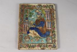 A 19TH CENTURY PERSIAN QAJAR MOULDED GLAZED POTTERY TILE, depicting a seated royal figure with