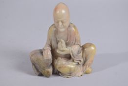 A CHINESE CARVED SOAPSTONE LOUHAN FIGURE, 13cm high.