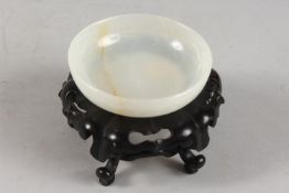 A CHINESE WHITE JADE BOWL ON HARDWOOD STAND, with applied collection sticker to base, bowl 9.5cm