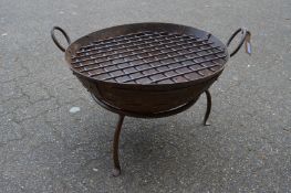 A wrought iron fire pit with stand.