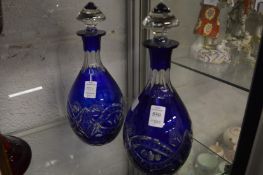 A pair of Bohemian blue cut glass decanters and stoppers.