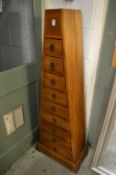 A pyramid shaped tall chest of drawers.