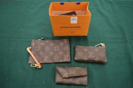 Three Louis Vuitton purses.