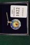 A sterling silver and enamel sunburst pendant and chain.